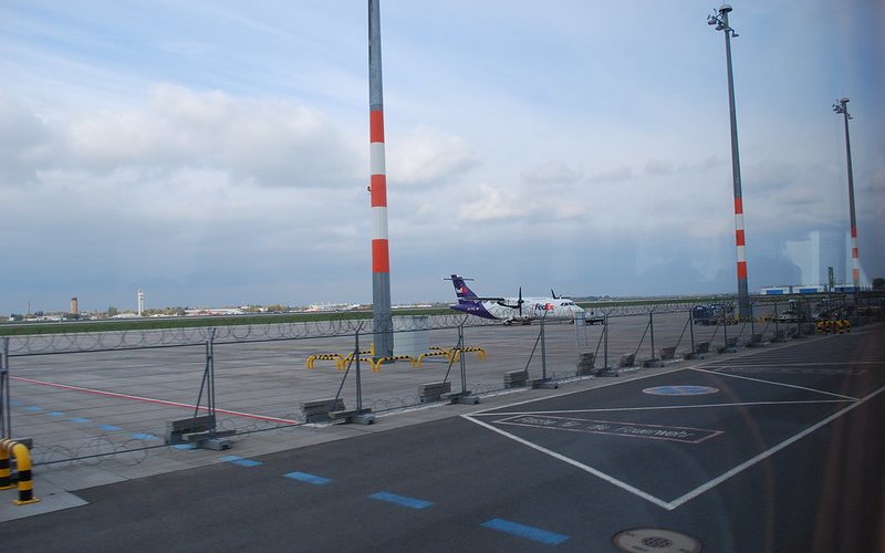 Aeroplan standing under clear sky at Berlin Airport.