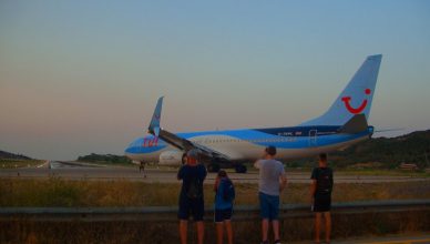 Famiily clicking pictures of a plane in Greece.