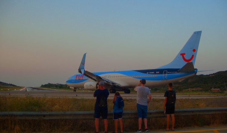 Famiily clicking pictures of a plane in Greece.