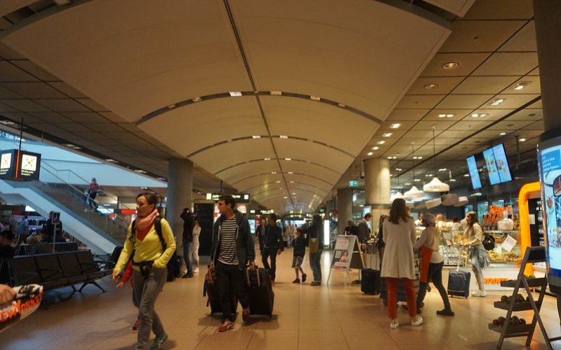 People walking with their luggage at Hamburg Airport.