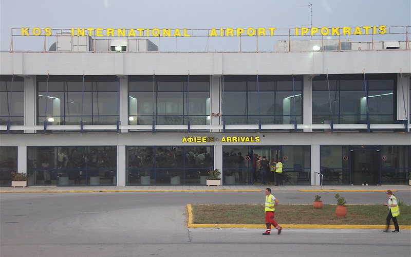 Man and woman at Kos airport wearing security check yellow jackets.