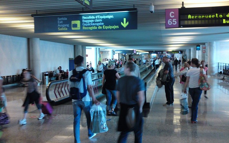 Passengers walking with their luggage at mallorca airport 