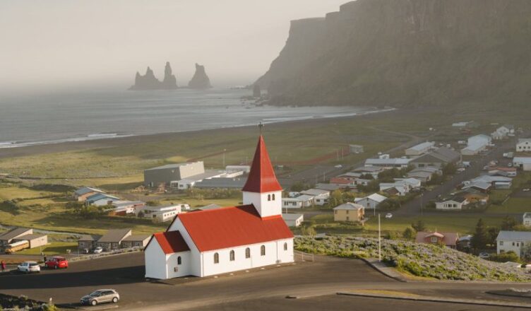 White and red house near road in Iceland.