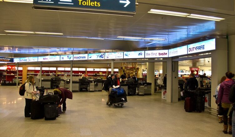 Passengers with their luggage at an airport in Iceland.