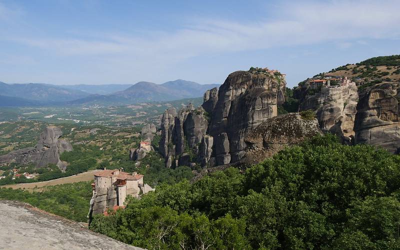 Huge mountains in Greece around thick forests.