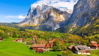 Switzerland view with mountains and green fields in the background.