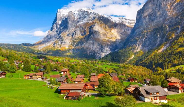 Switzerland view with mountains and green fields in the background.