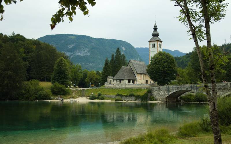 Lake Bohinj with a view of a church behind it. 