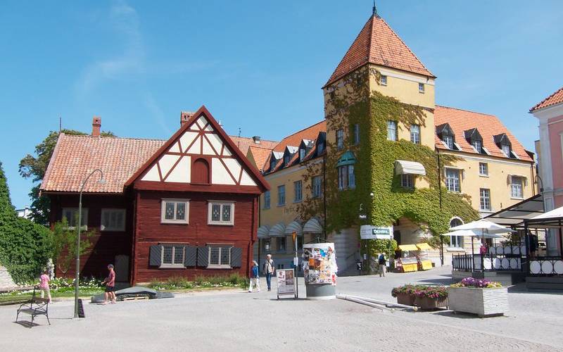 People roaming around on the road near buildings in Visby in Sweden.