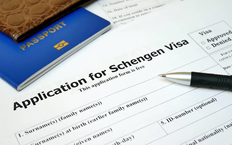 Schengen Visa application form with a pen placed on top