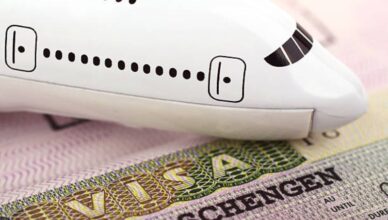 A model airplane placed on a Schengen visa document, symbolizing travel and visa requirements for Europe