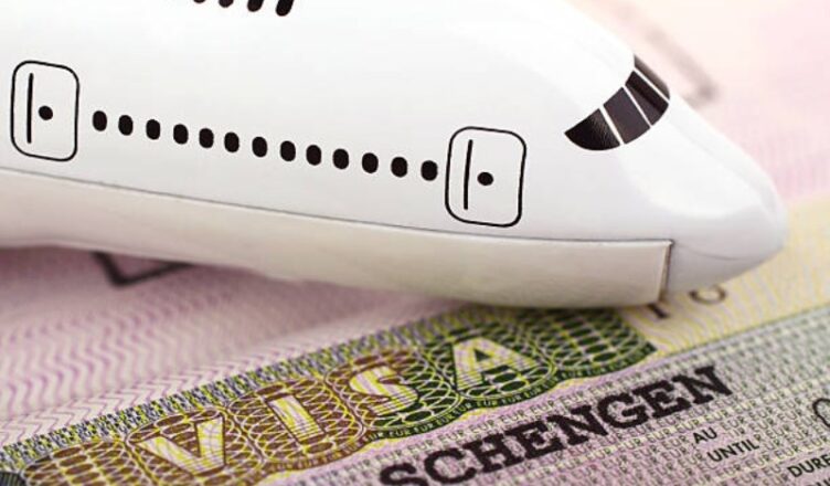 A model airplane placed on a Schengen visa document, symbolizing travel and visa requirements for Europe