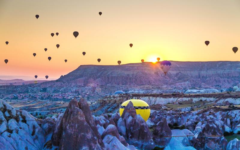 Colourful hot air balloons over Cappadocia’s rocky landscape at sunrise