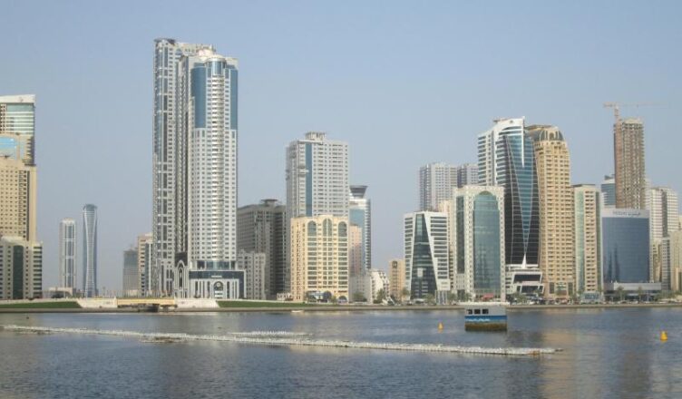 Tall buildings in Sharjah, UAE overlooking a waterway with a boat